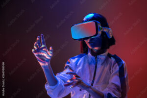 Excited young woman touching air while having virtual reality experience in neon light